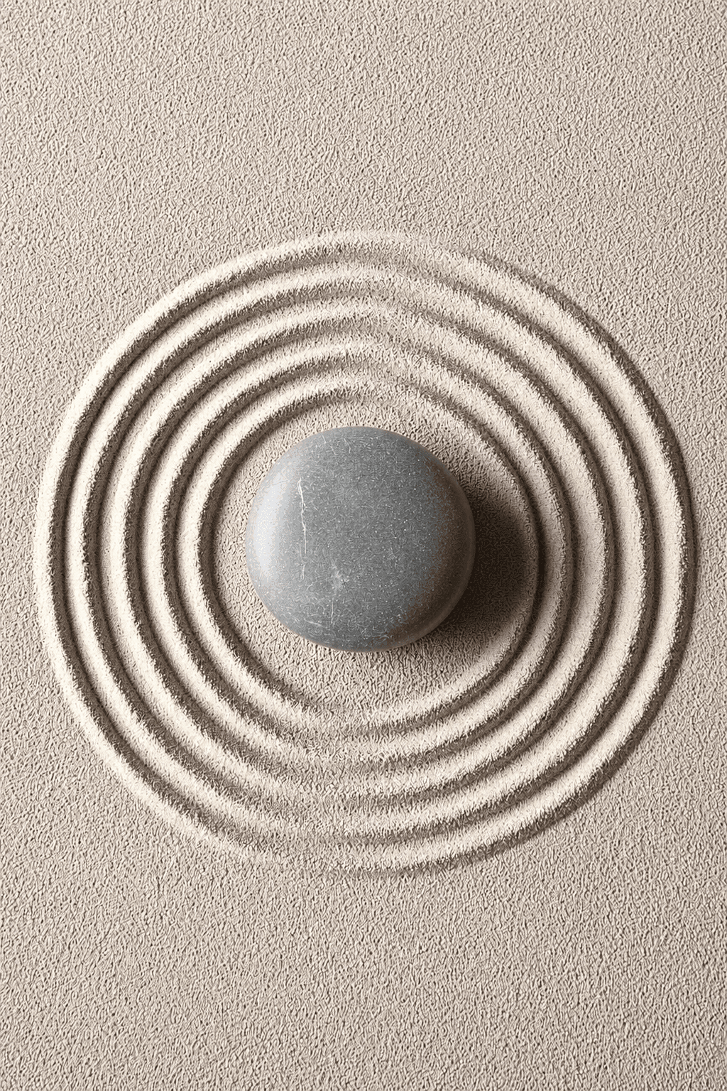 A stone resting in a raked zen sand garden
